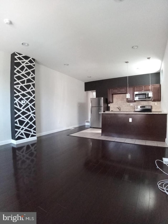 kitchen featuring light wood finished floors, baseboards, decorative backsplash, appliances with stainless steel finishes, and light countertops