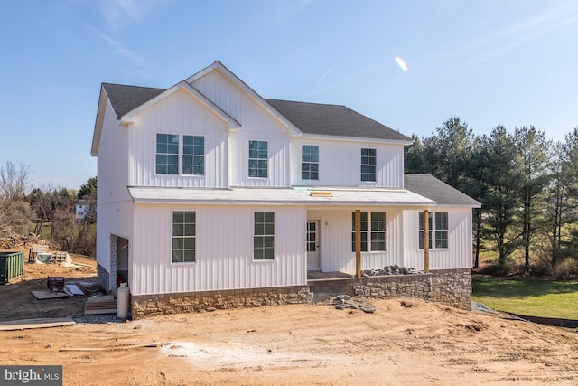 modern farmhouse style home with a shingled roof and covered porch