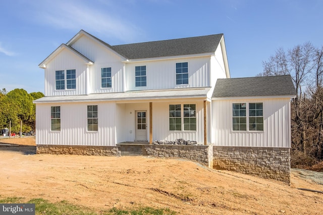 modern farmhouse featuring covered porch and a shingled roof