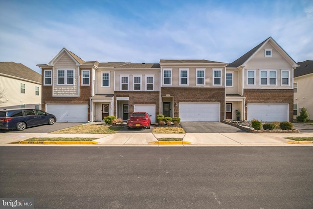 multi unit property with concrete driveway, an attached garage, and brick siding