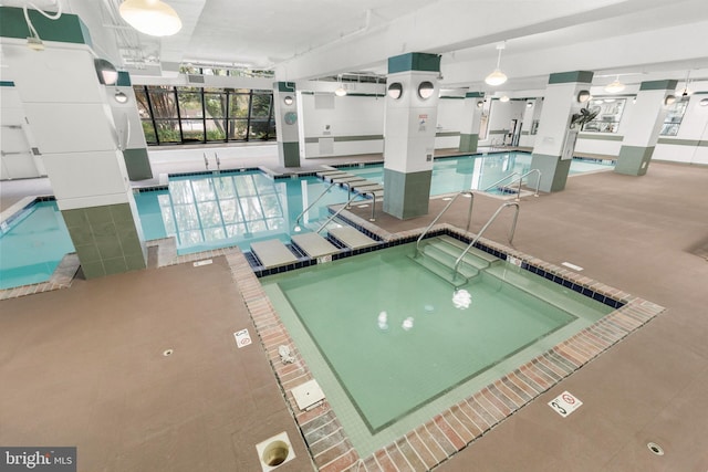 community pool featuring an indoor in ground hot tub