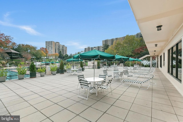 view of patio with a view of city and fence