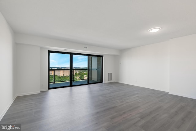 empty room with visible vents, baseboards, and wood finished floors