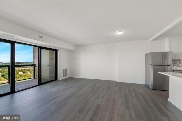 unfurnished living room featuring visible vents and wood finished floors