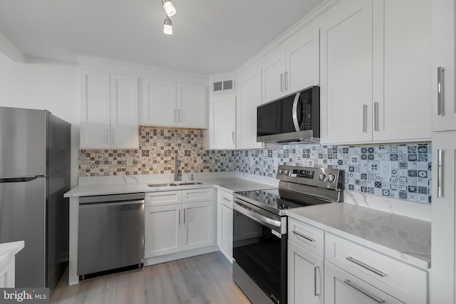 kitchen featuring a sink, visible vents, white cabinetry, appliances with stainless steel finishes, and tasteful backsplash