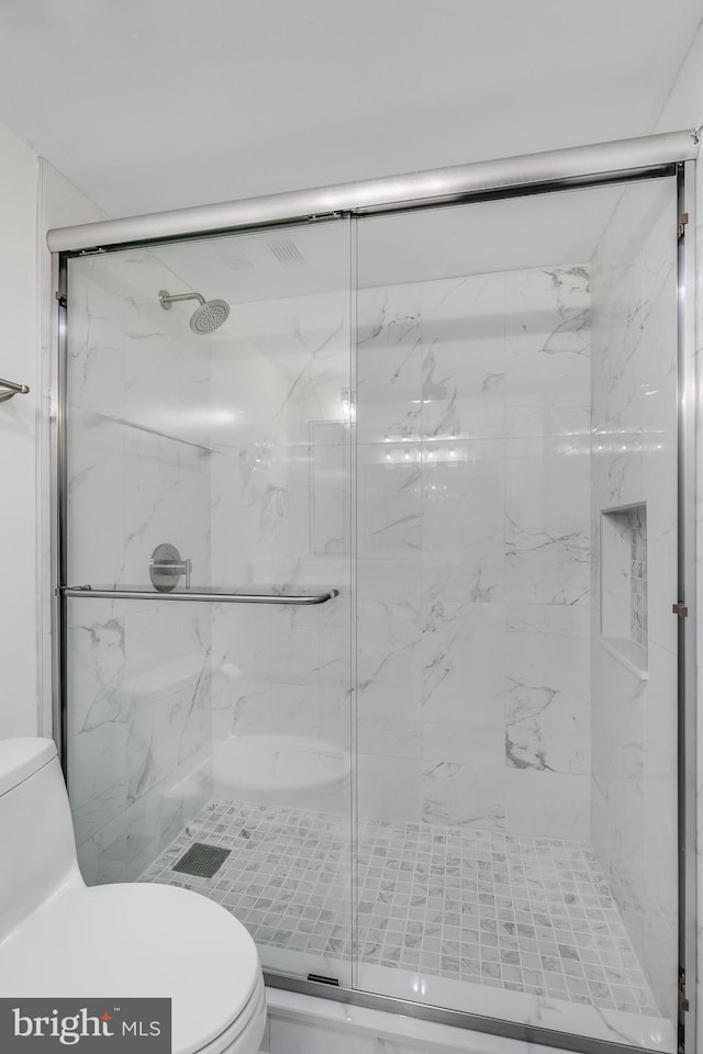 full bathroom featuring a marble finish shower and toilet