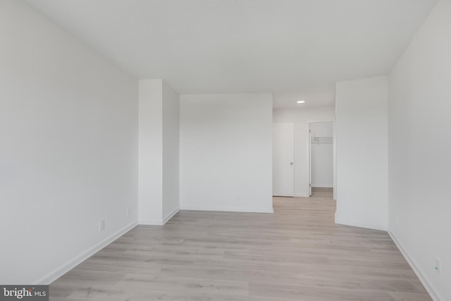 spare room with light wood-type flooring, baseboards, and recessed lighting