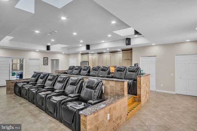 cinema room featuring a skylight, light tile patterned floors, baseboards, and recessed lighting