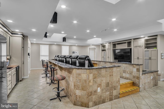 kitchen featuring stone counters, a large island, light tile patterned floors, recessed lighting, and a kitchen breakfast bar