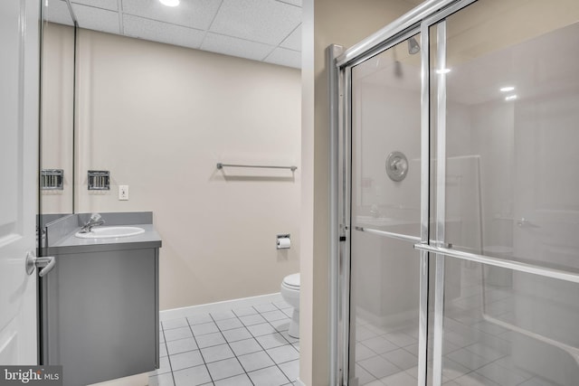 bathroom featuring a stall shower, tile patterned flooring, a drop ceiling, and vanity