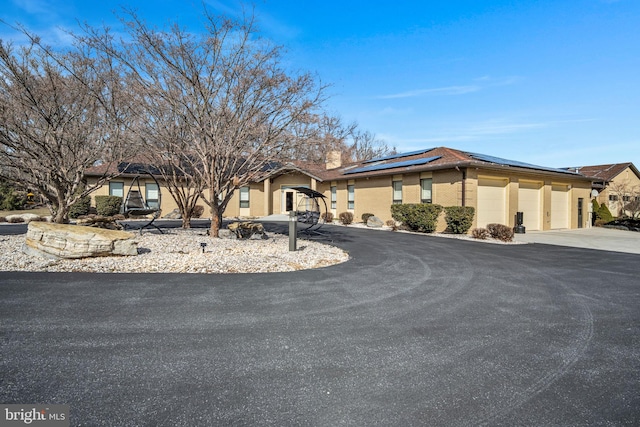 view of front of property with a garage and solar panels