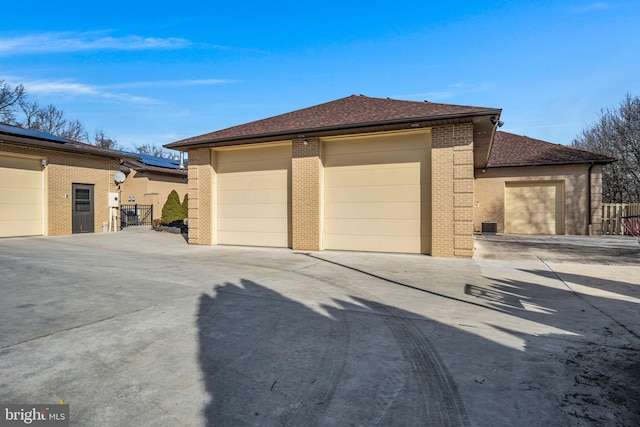 garage featuring fence and solar panels