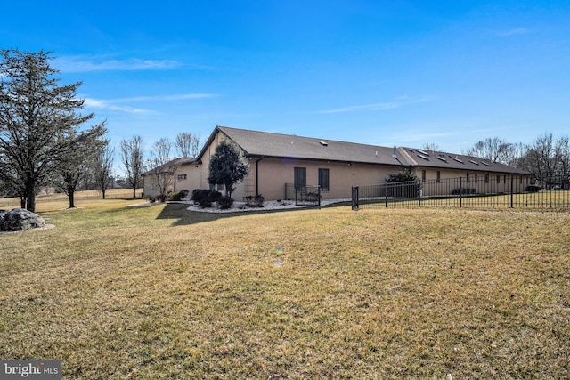 back of house with a lawn and fence