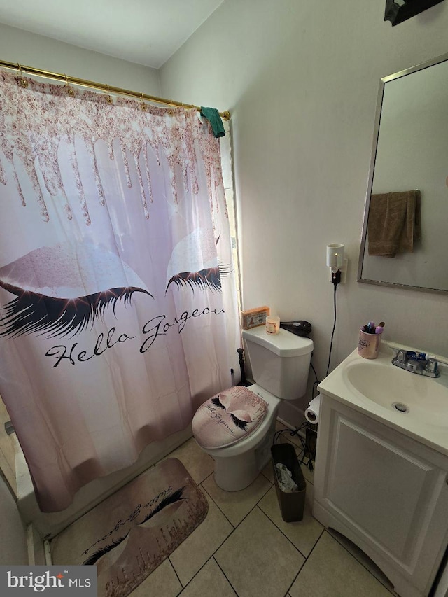 bathroom featuring toilet, curtained shower, vanity, and tile patterned floors