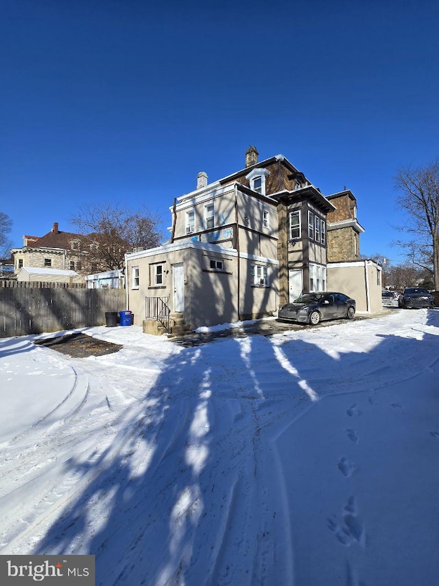 view of front facade featuring entry steps and fence