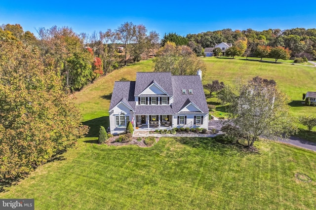 view of front of house with a patio, a chimney, and a front lawn