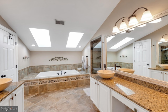 full bathroom featuring visible vents, a garden tub, a stall shower, and vaulted ceiling