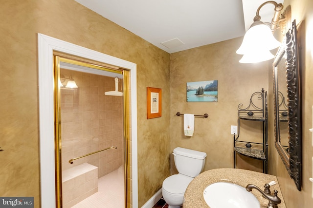 bathroom featuring a shower stall, toilet, and a sink