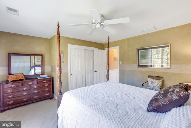 bedroom with a closet, visible vents, light colored carpet, and a ceiling fan