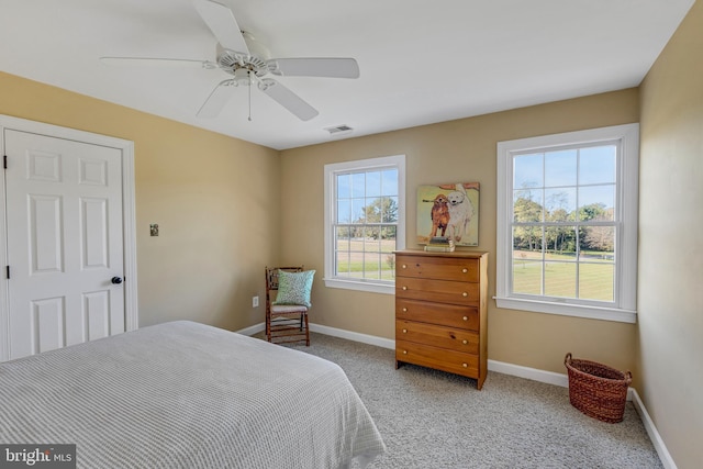 bedroom with light colored carpet, baseboards, visible vents, and a ceiling fan