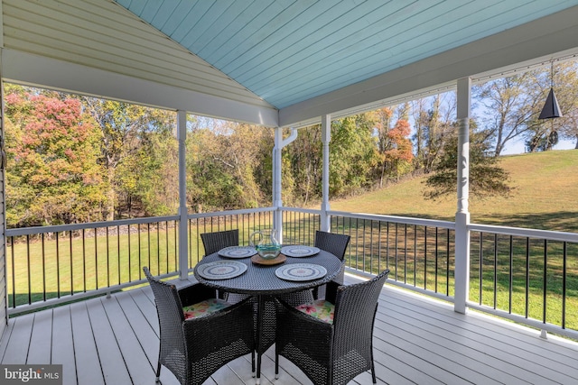 wooden deck featuring outdoor dining area and a yard