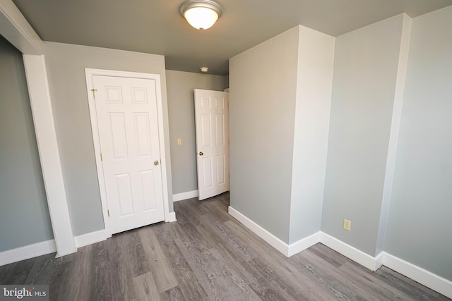 unfurnished bedroom with baseboards and wood finished floors