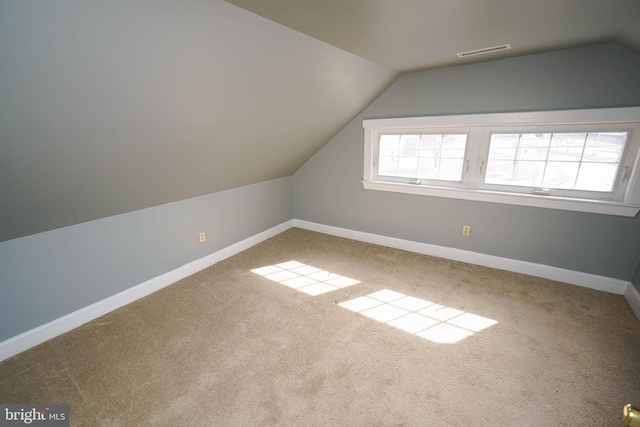 bonus room with lofted ceiling, carpet floors, baseboards, and visible vents