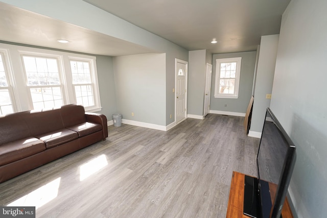 unfurnished living room with recessed lighting, wood finished floors, and baseboards