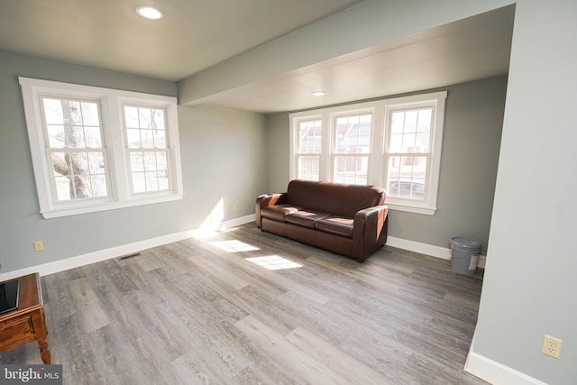 living area with visible vents, baseboards, wood finished floors, and recessed lighting