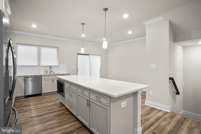 kitchen with a sink, gray cabinets, freestanding refrigerator, built in microwave, and dishwasher