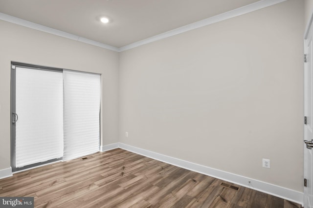 unfurnished bedroom with crown molding, baseboards, and wood finished floors