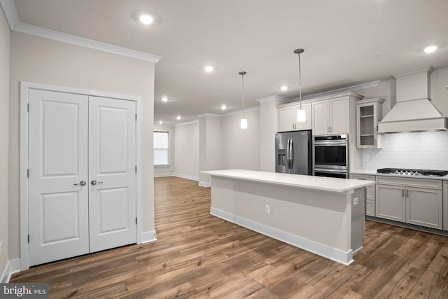 kitchen with tasteful backsplash, stainless steel appliances, ornamental molding, and custom range hood