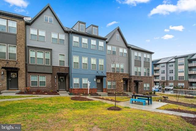 exterior space featuring brick siding, a front lawn, and board and batten siding