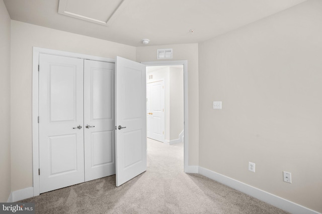 unfurnished bedroom featuring light colored carpet, a closet, visible vents, and baseboards