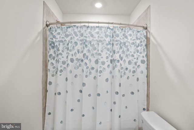 bathroom with curtained shower and toilet