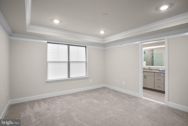 unfurnished bedroom featuring a tray ceiling, ornamental molding, and light colored carpet