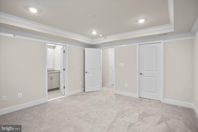 unfurnished bedroom with recessed lighting, light colored carpet, baseboards, a tray ceiling, and crown molding