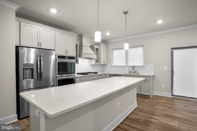 kitchen featuring appliances with stainless steel finishes, dark wood-style flooring, a sink, custom exhaust hood, and backsplash