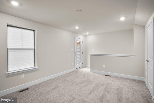 spare room with carpet floors, baseboards, visible vents, and recessed lighting