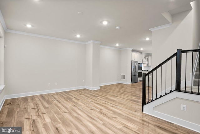 interior space featuring baseboards, light wood-style flooring, stairway, and crown molding