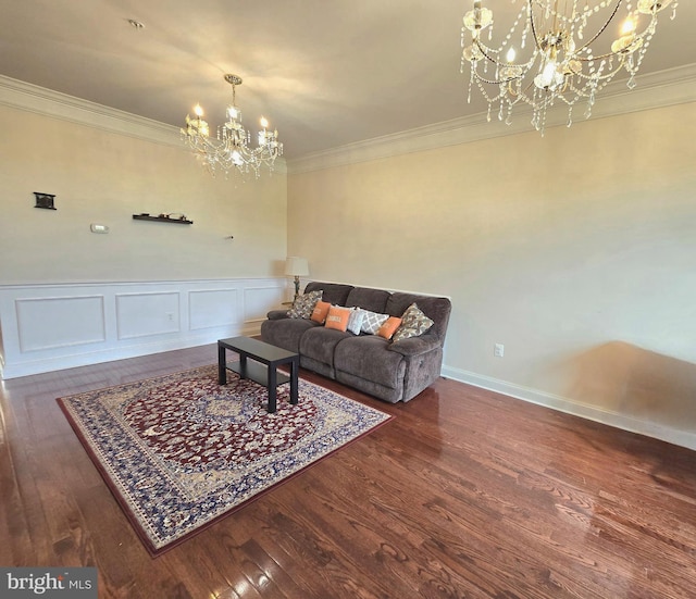 living area featuring ornamental molding, wood finished floors, and an inviting chandelier