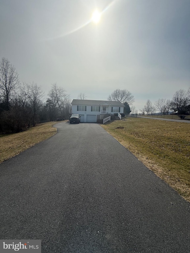 view of front facade with aphalt driveway and a front yard