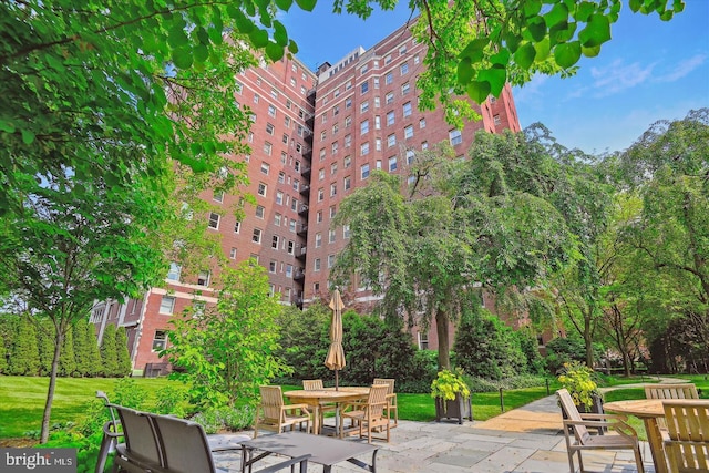 surrounding community with a patio area, a lawn, and outdoor dining space