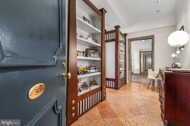 hall with built in shelves and crown molding