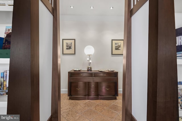 corridor with baseboards and ornamental molding