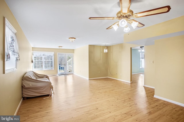 interior space featuring ceiling fan, wood finished floors, and baseboards