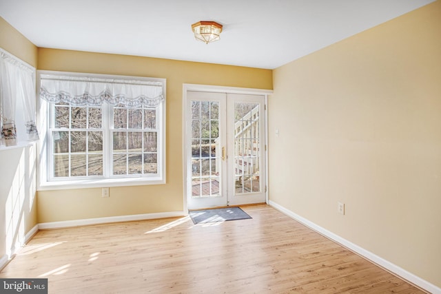 doorway to outside with baseboards, wood finished floors, and french doors