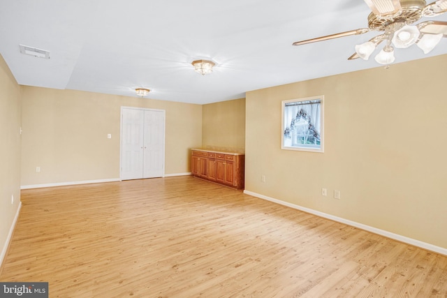 unfurnished room featuring light wood-type flooring, visible vents, ceiling fan, and baseboards