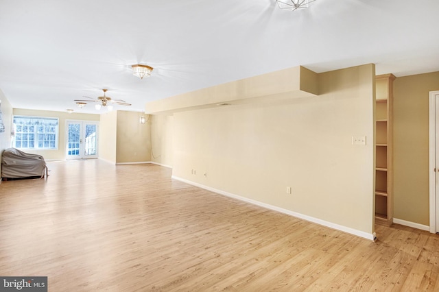 unfurnished living room with a ceiling fan, baseboards, and light wood finished floors