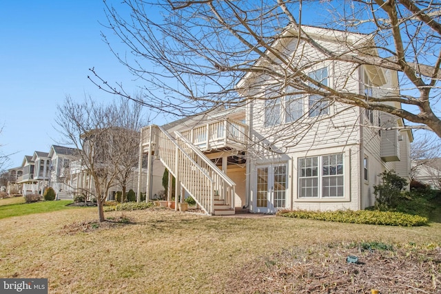 back of property with a deck, french doors, a lawn, and stairway